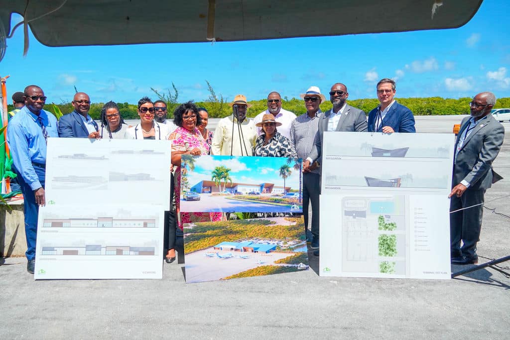 TCIAA Officials and DNA Workshops Dyke Nelson stand behind several boards displaying the new design of the Clifford Gardiner International Airport